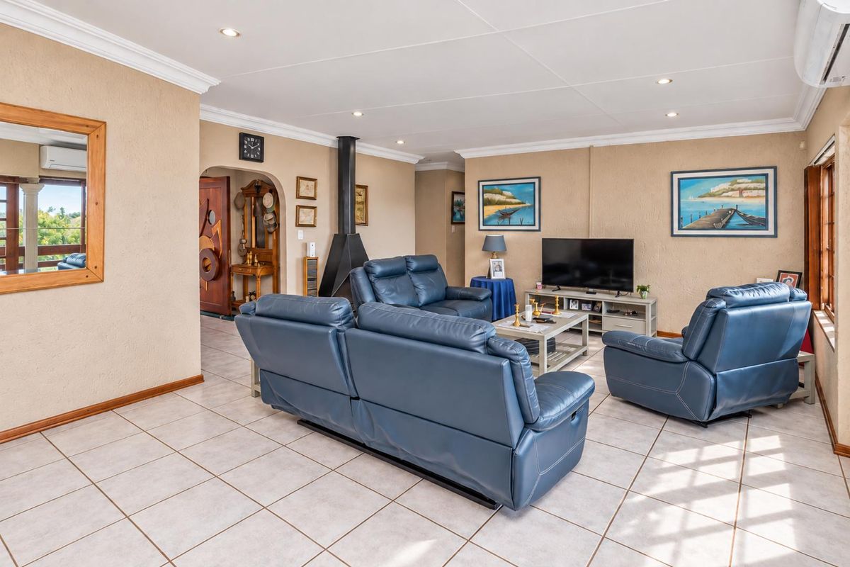 Spacious living room featuring tiled flooring, a modern freestanding fireplace, recessed lighting, and an air conditioning unit, offering a comfortable and functional living space.