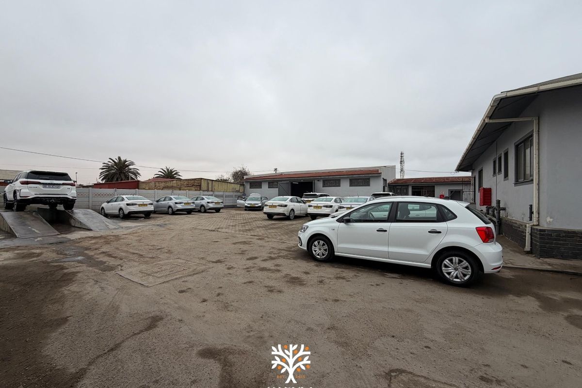 Spacious industrial yard area featuring paved surfaces, perimeter walling, and a vehicle ramp, suitable for commercial or automotive operations.