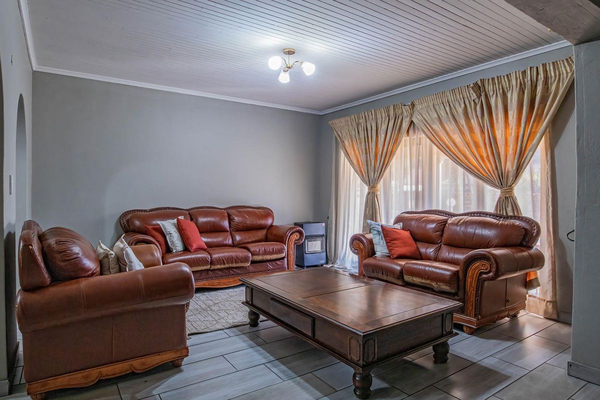 A comfortable living room featuring tiled flooring and a classic tongue and groove ceiling, providing a neutral foundation for your personal style.