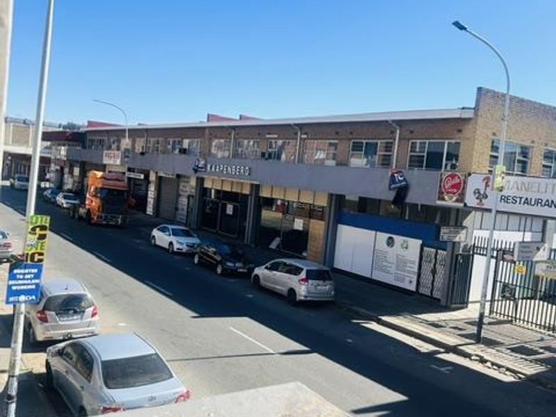 An elevated street-level view showing the building facade, surrounding road, and local commercial infrastructure.