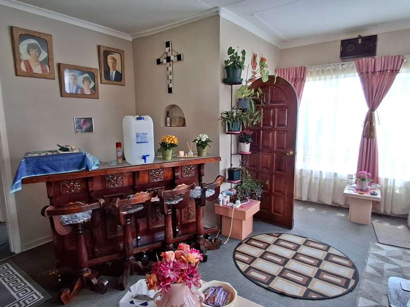 A living area featuring a built-in wooden bar counter, an arched wooden door, and a recessed wall niche, offering a traditional interior layout.