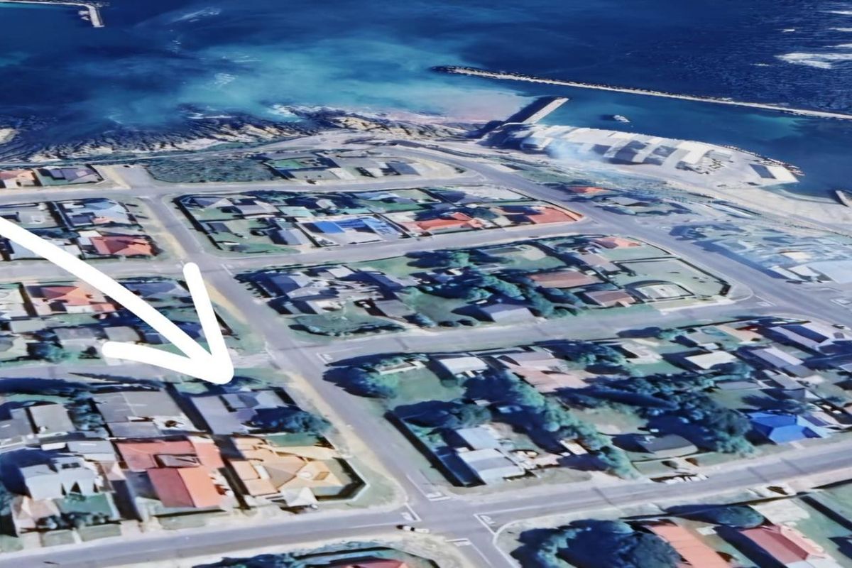Aerial view of the residential neighborhood and coastal surroundings, highlighting the property location within the local street layout.