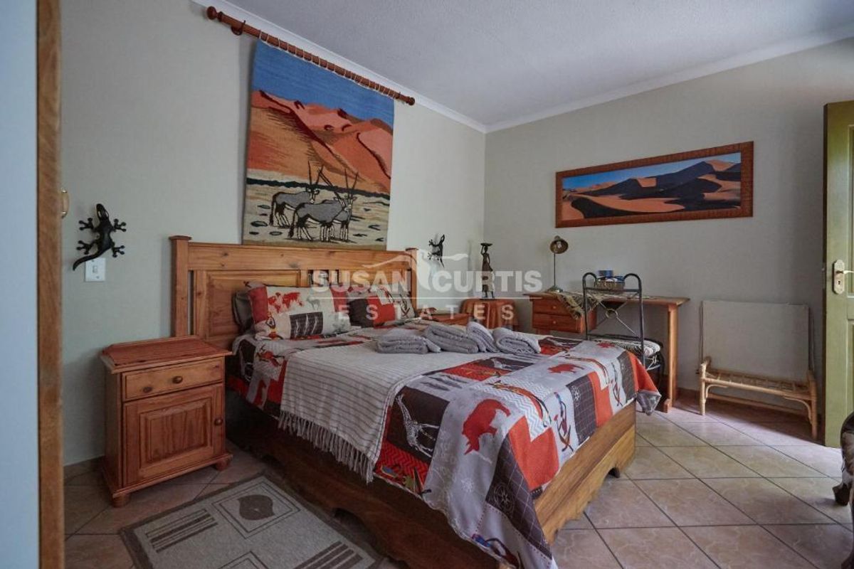 A bedroom featuring tiled flooring and neutral wall finishes, providing a functional space for guests.