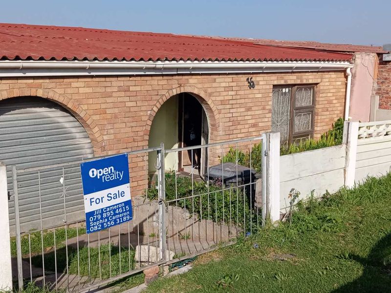 Front exterior view of a single-story brick house featuring a garage, arched entrance, and precast concrete boundary wall.
