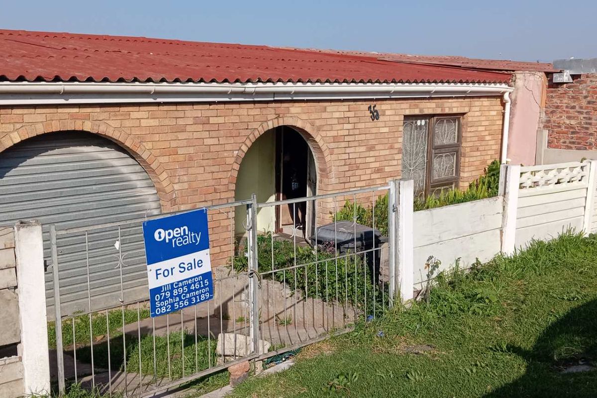 Front exterior view of a single-story brick house featuring a garage, arched entrance, and precast concrete boundary wall.