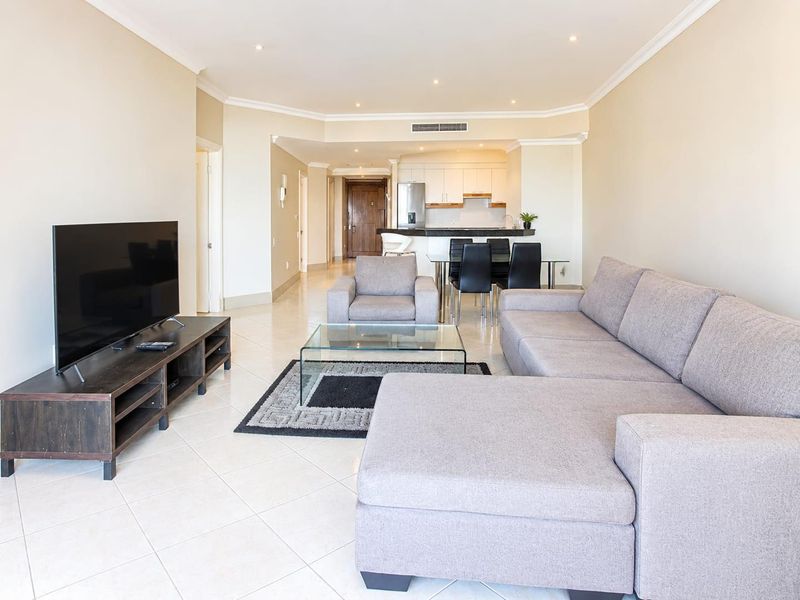 Spacious open-plan living and dining area featuring tiled floors, recessed lighting, ducted air conditioning, and a modern kitchen with a breakfast bar.