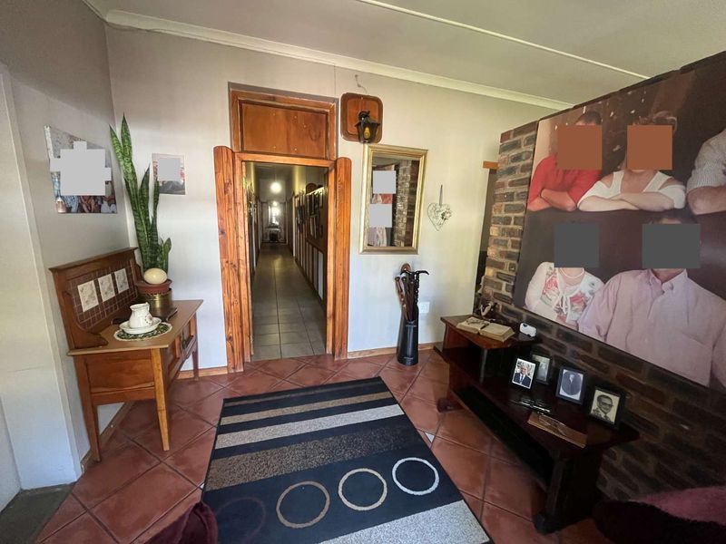 Entrance hall featuring tiled flooring, an exposed brick feature wall, and a wooden door frame leading into the home's hallway.