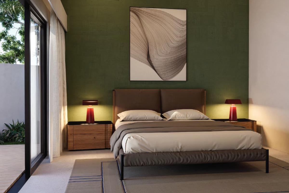 A modern bedroom featuring a textured green accent wall, large sliding glass doors providing access to an outdoor patio, and high-quality finishes.