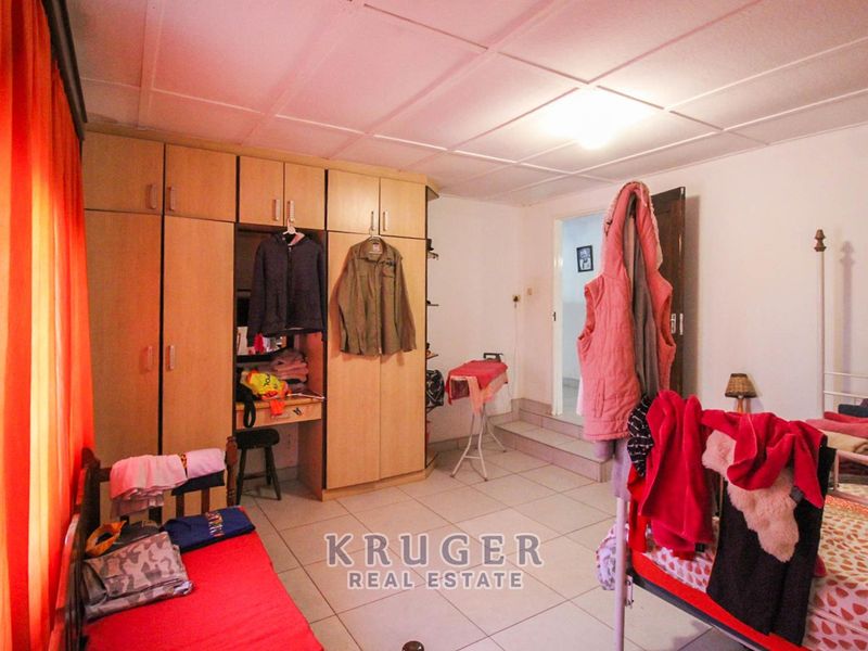 A bedroom featuring built-in cupboards, tiled flooring, and a tiled ceiling, offering functional storage space.