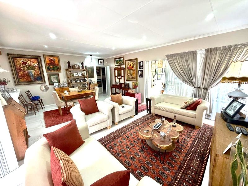 Spacious open-plan living and dining area featuring tiled flooring, recessed lighting, and large sliding glass doors providing access to the exterior.