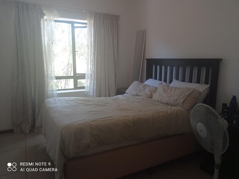 A standard bedroom featuring tiled flooring and a window with natural light, providing a functional space for rest.
