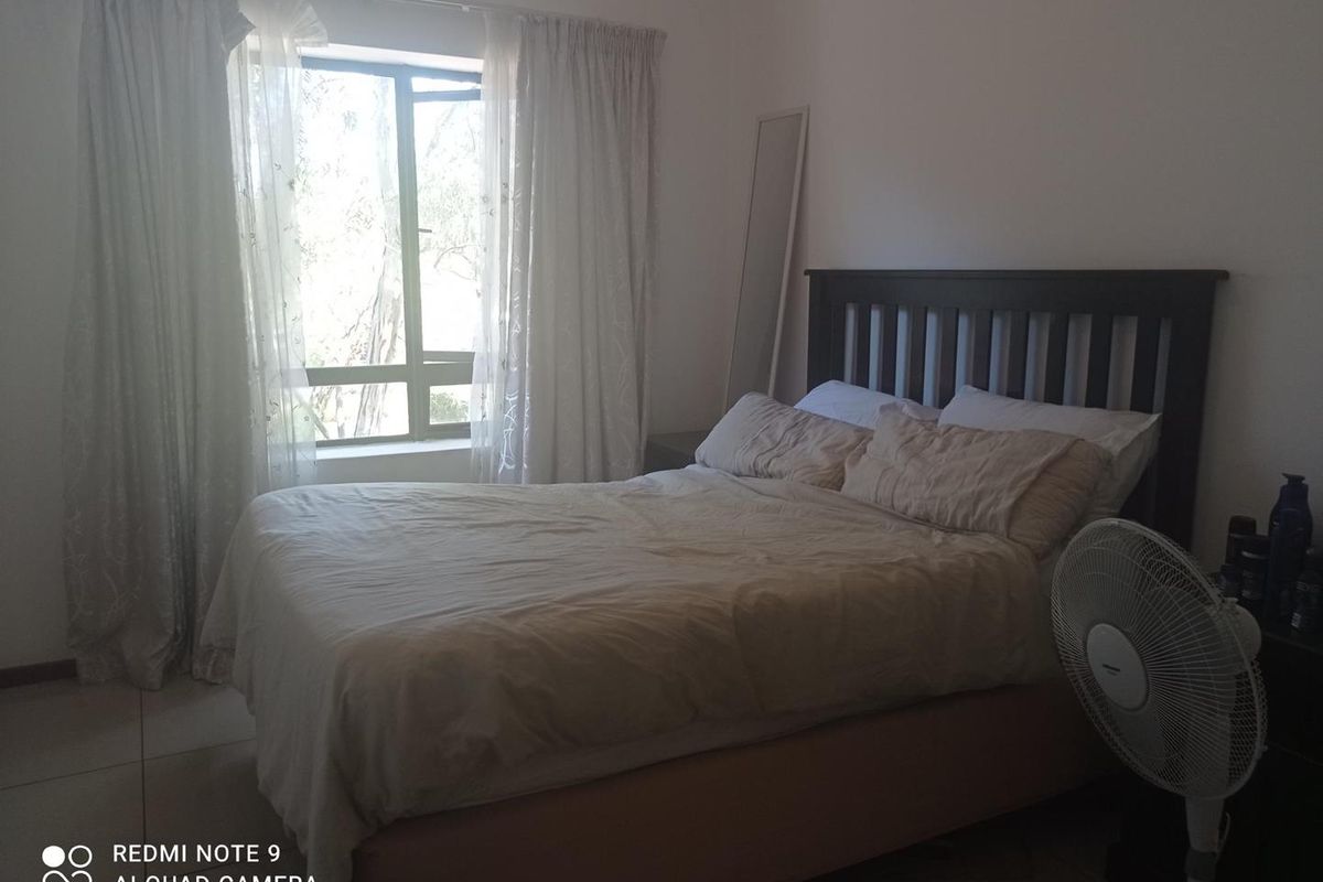 A standard bedroom featuring tiled flooring and a window with natural light, providing a functional space for rest.