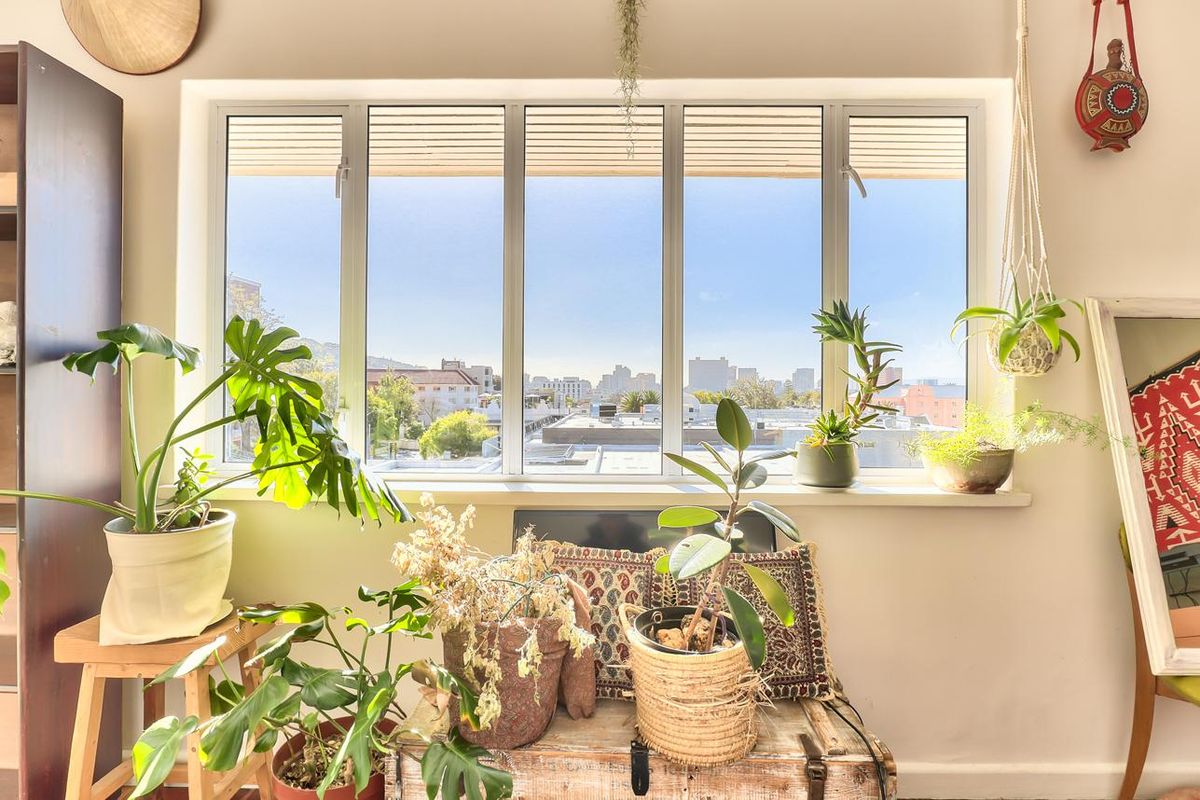 A bright living area featuring a large multi-pane window that provides ample natural light and an urban city view.