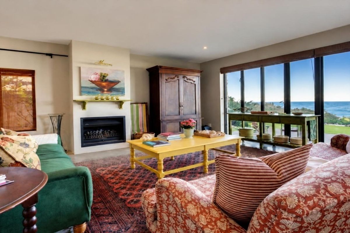 A comfortable living room featuring a fireplace and expansive floor-to-ceiling windows that offer stunning ocean views.