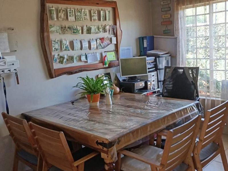 A functional dining area featuring tiled flooring and natural light, suitable for family meals or as a versatile living space.