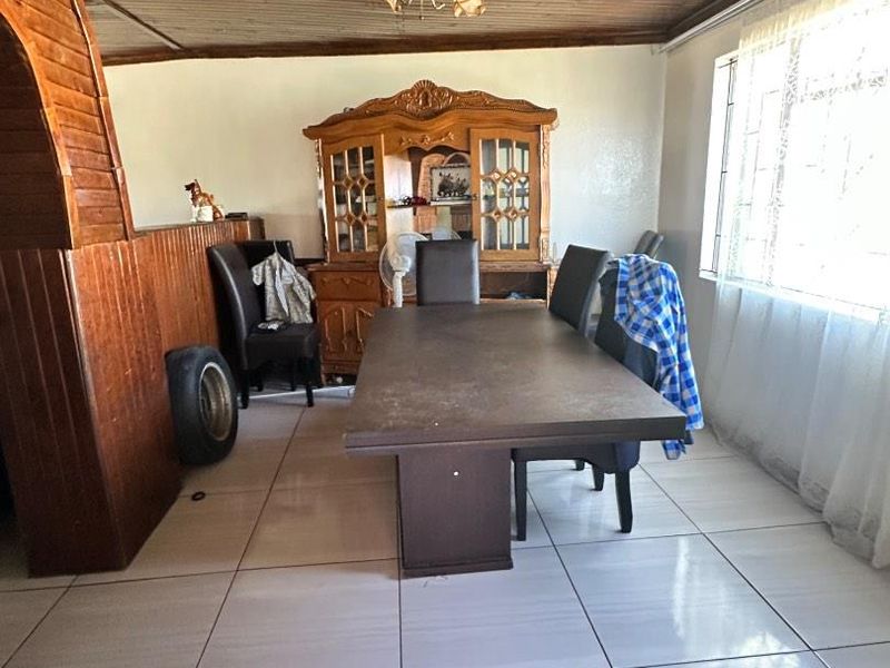 Dining room featuring a timber-clad ceiling, ceramic floor tiles, and a decorative timber room divider.