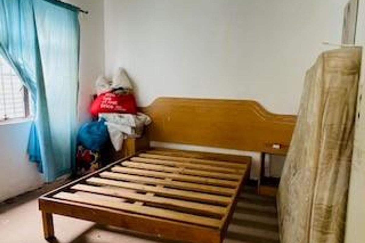 A bedroom featuring a built-in wooden headboard and frame, with a window providing natural light.