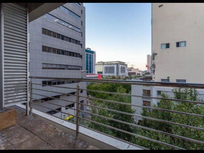 A balcony featuring a stainless steel balustrade and a privacy screen, offering an urban city view.