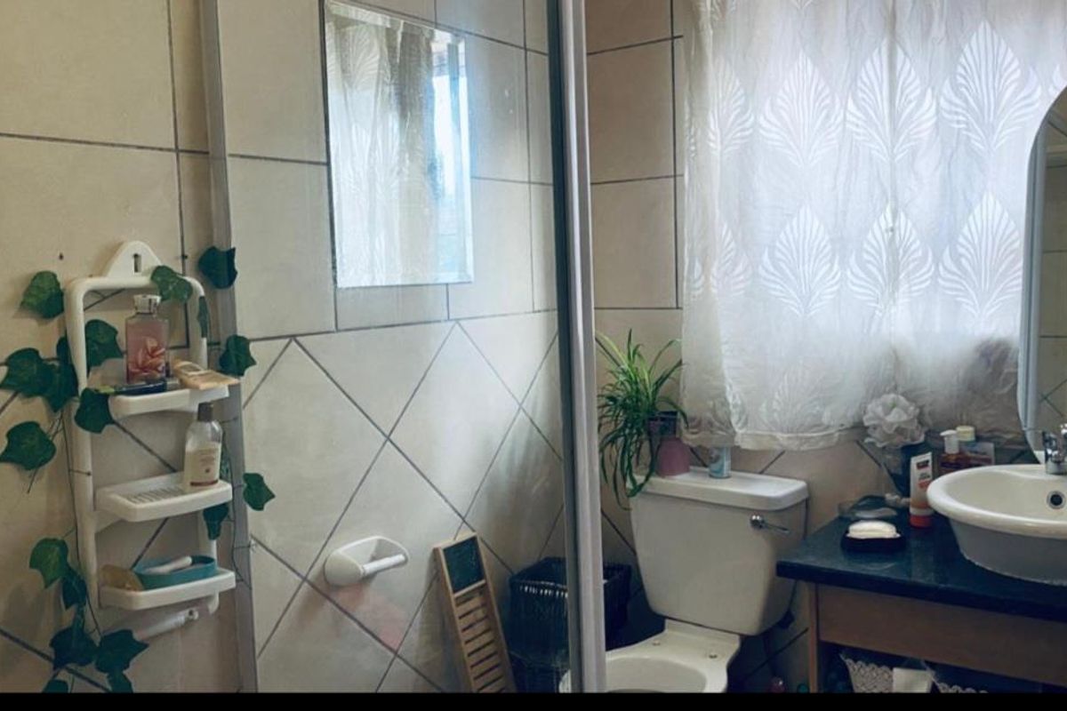 A functional bathroom featuring tiled walls, a vanity with a basin, and a standard toilet setup.
