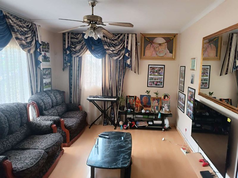 A living room featuring laminate flooring and a ceiling fan, providing a functional space for relaxation.
