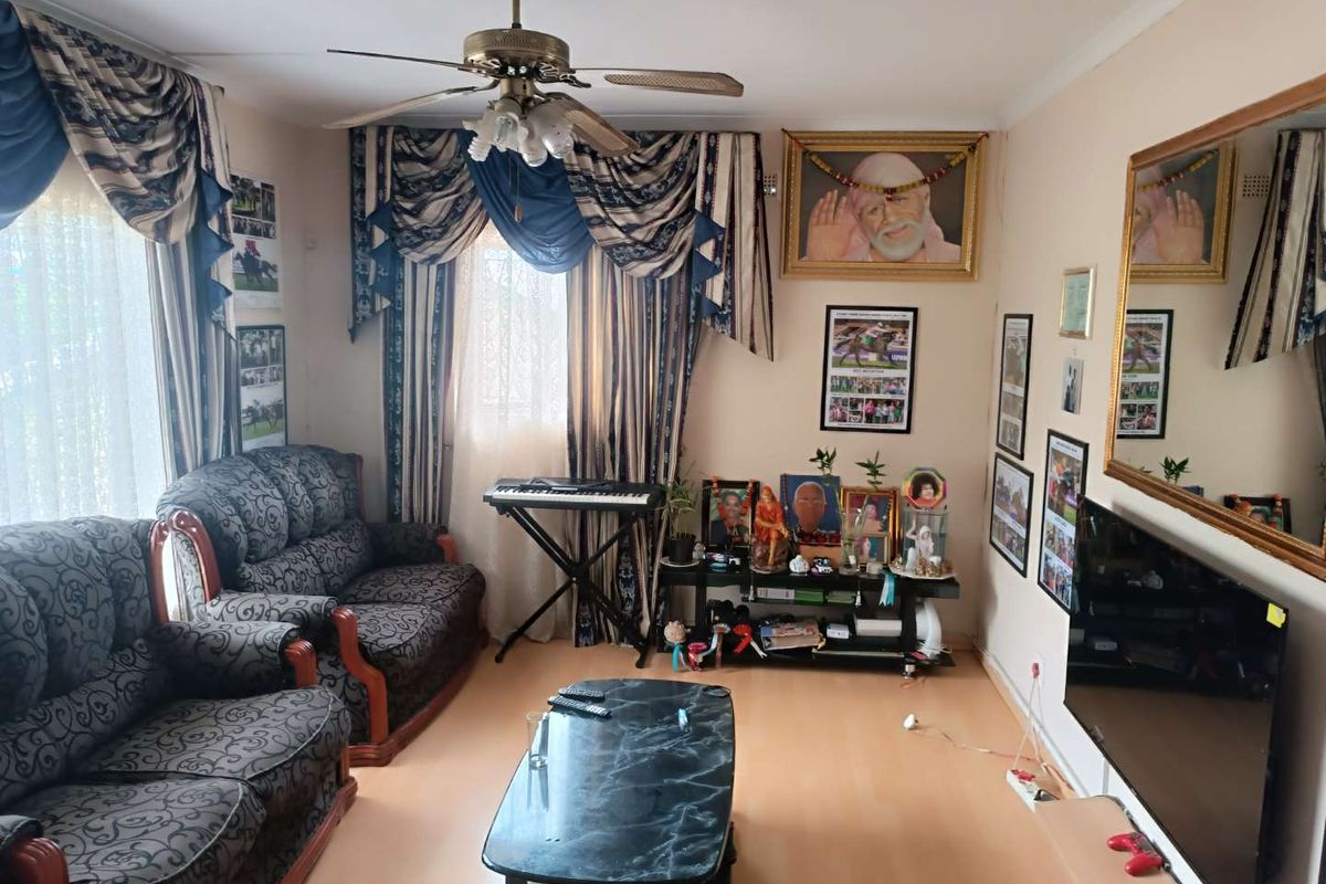 A living room featuring laminate flooring and a ceiling fan, providing a functional space for relaxation.