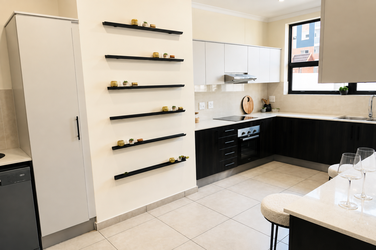Modern kitchen featuring dark lower cabinetry, light upper cabinets, stone countertops, integrated appliances, and sleek floating wall shelving.