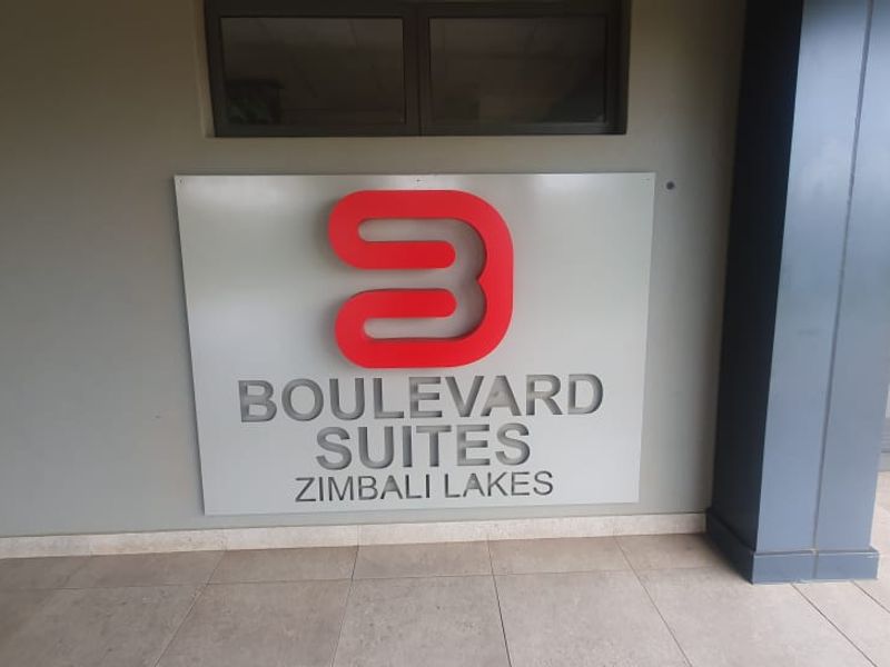 Entrance area of Boulevard Suites at Zimbali Lakes, featuring modern signage and a glass door entry.