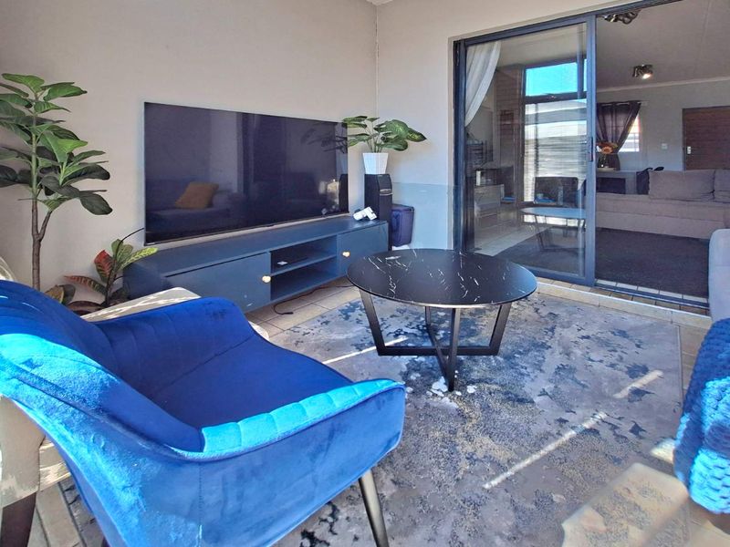 A covered patio area featuring tiled flooring and a large sliding glass door providing access to the interior living space.
