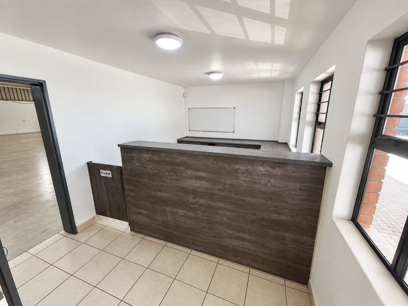 A clean, modern reception area featuring a wood-look service counter, tiled flooring, and large windows with security bars, suitable for a professional office or workspace.