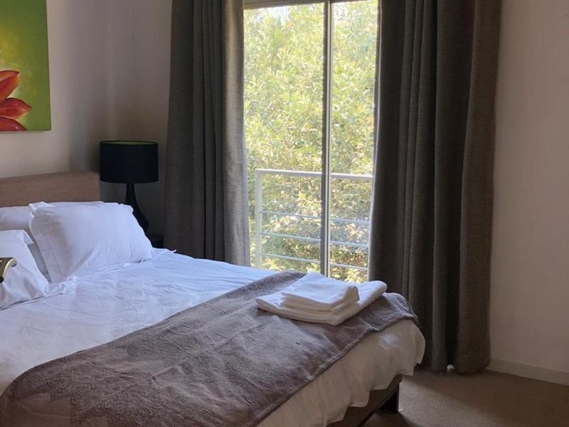 A comfortable bedroom featuring carpeted flooring, recessed lighting, and a sliding glass door that provides access to an outdoor balcony area.