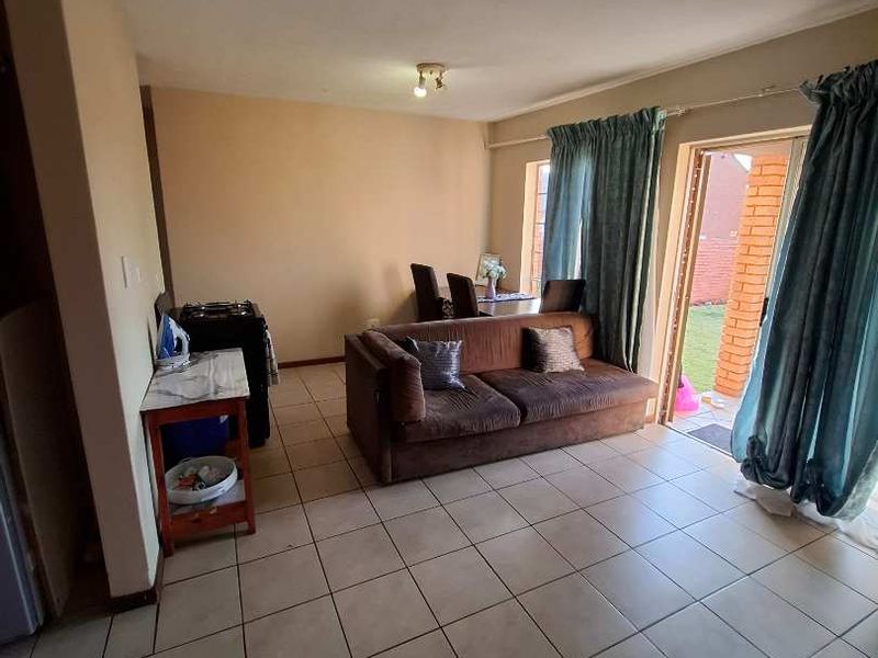 Open-plan living area featuring tiled flooring and a sliding glass door providing access to the outdoor space.