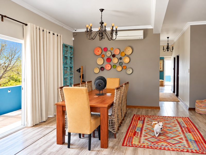 A bright dining room featuring laminate flooring, crown molding, a split-system air conditioner, and a sliding glass door leading to an outdoor balcony.