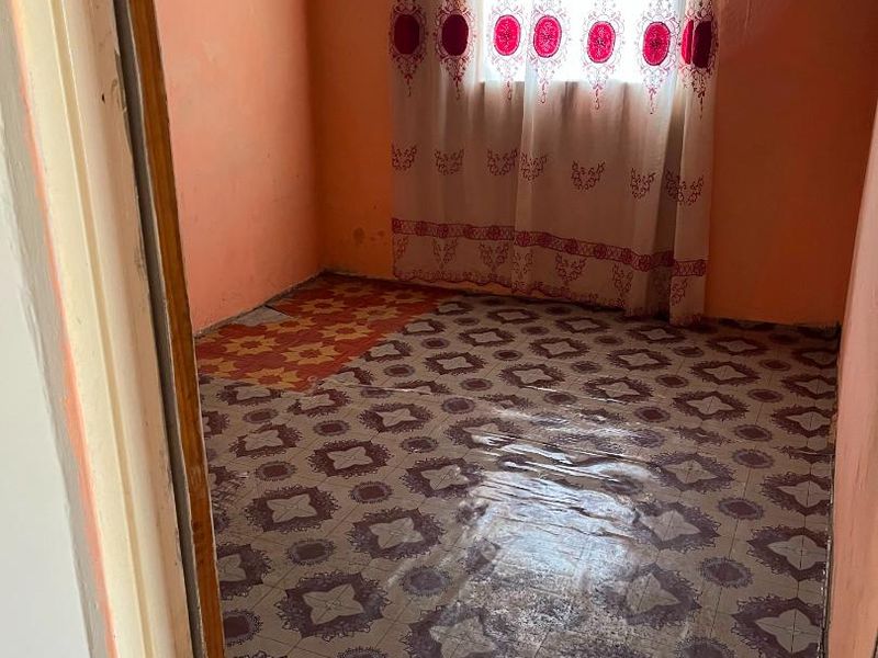 A small bedroom featuring patterned vinyl flooring and painted walls, presenting a blank canvas for renovation and modernization.