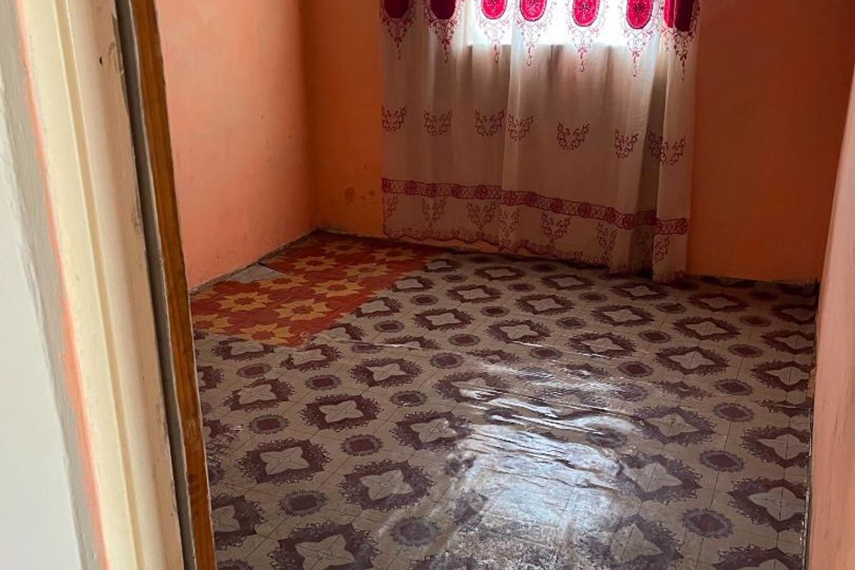 A small bedroom featuring patterned vinyl flooring and painted walls, presenting a blank canvas for renovation and modernization.