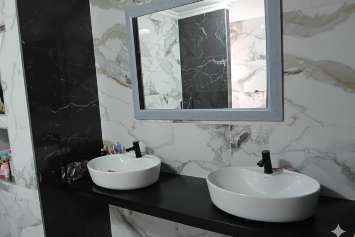 Modern bathroom featuring a double vanity with vessel sinks, black fixtures, and striking marble-effect wall tiling.