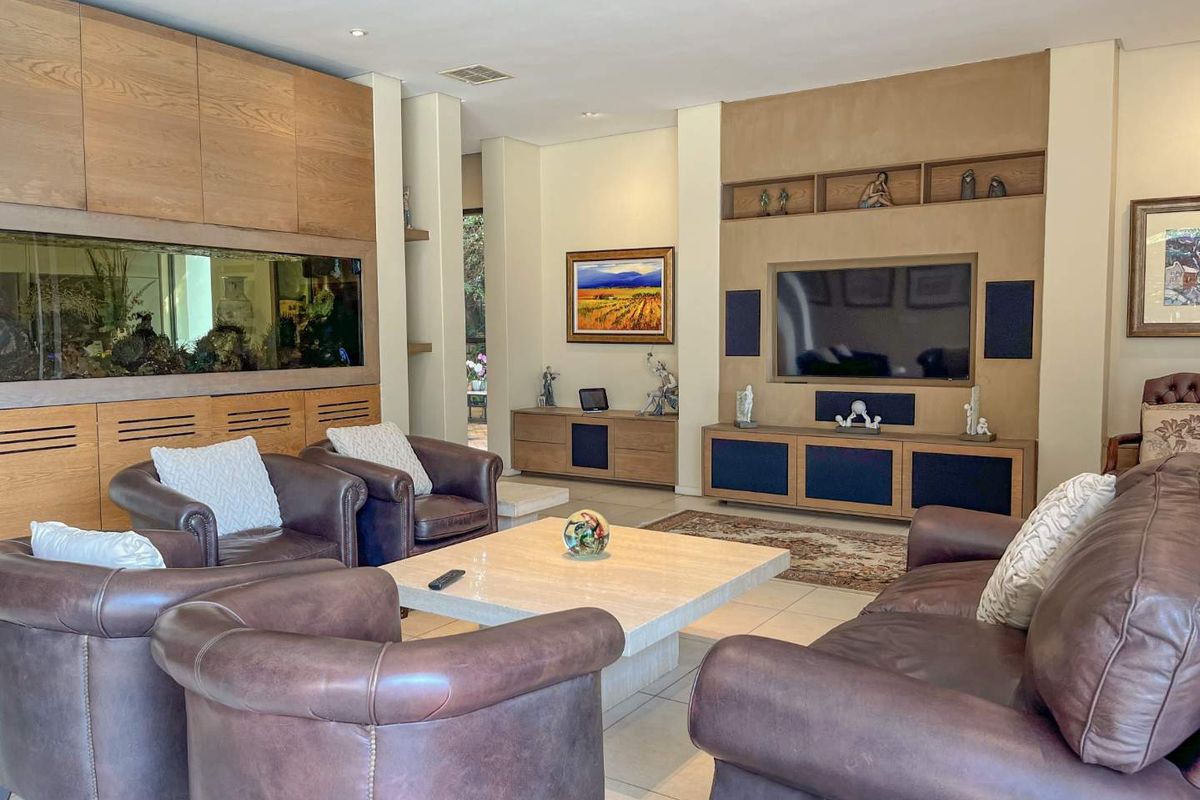 Spacious living room featuring custom built-in cabinetry, integrated aquarium, and a dedicated media wall with recessed shelving.