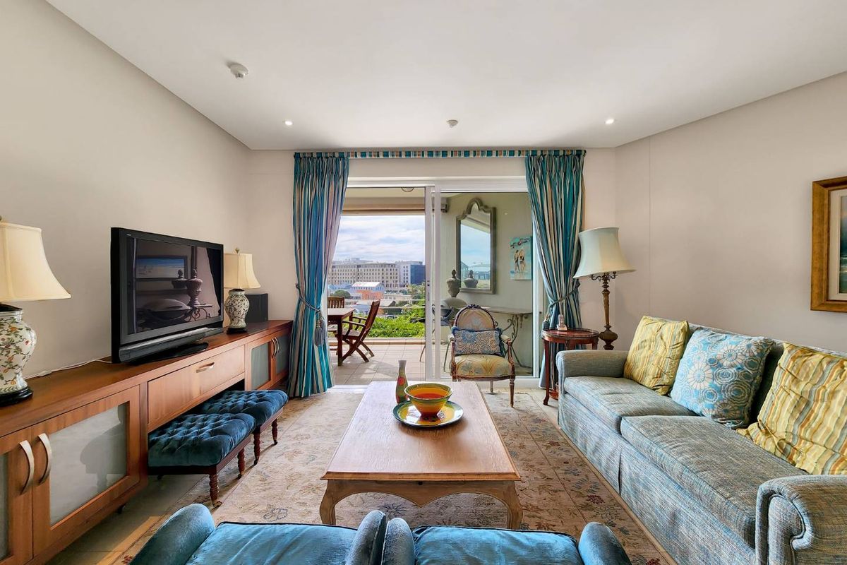A comfortable living room featuring recessed lighting and a large sliding glass door that provides access to an outdoor balcony area.