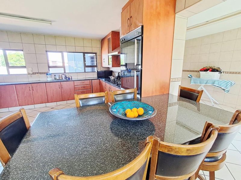 A functional kitchen featuring granite countertops, built-in cabinetry, and integrated appliances, offering a practical layout for daily cooking and dining.