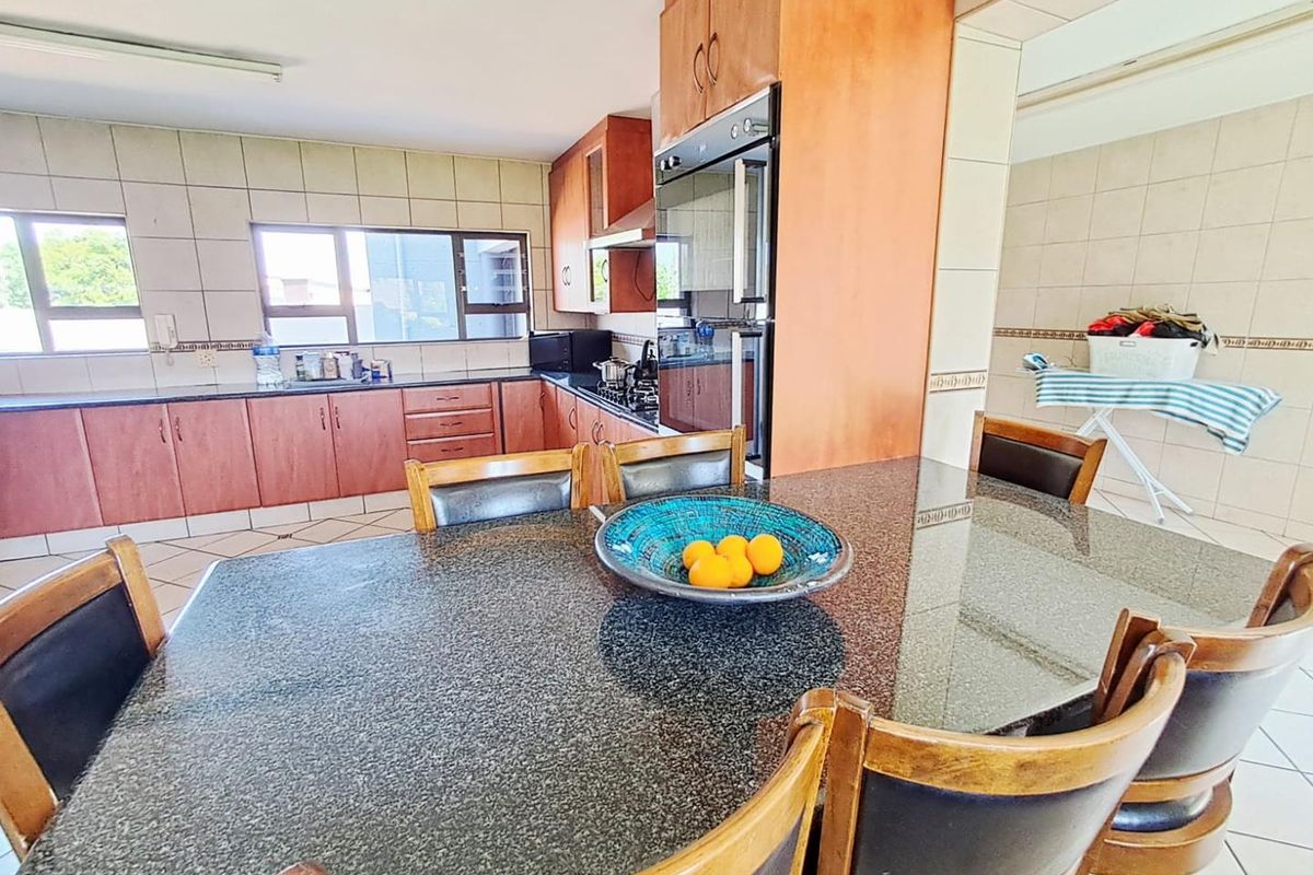 A functional kitchen featuring granite countertops, built-in cabinetry, and integrated appliances, offering a practical layout for daily cooking and dining.