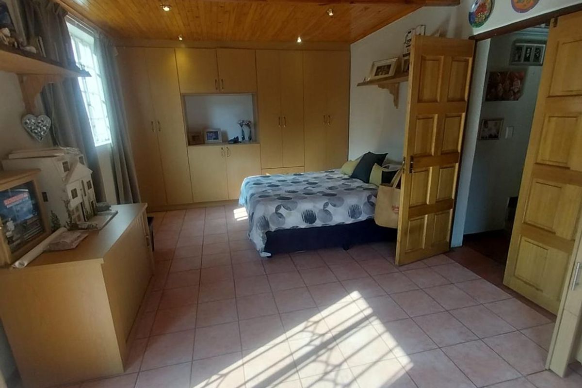 Spacious bedroom featuring built-in wooden cabinetry, tiled flooring, and a timber-clad ceiling with recessed lighting.