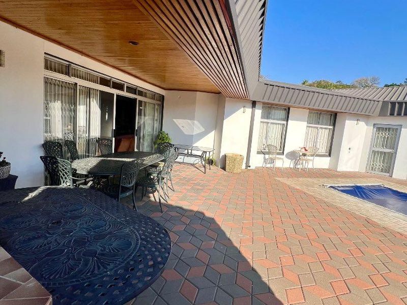 Spacious covered patio area featuring paved flooring and timber ceiling, providing direct access to the swimming pool and main living areas.