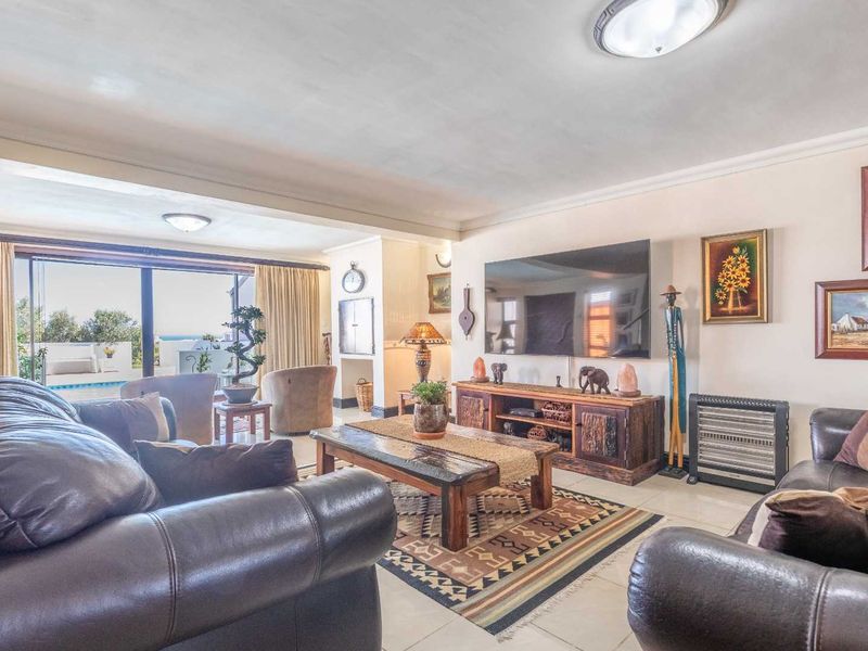 Spacious living room featuring tiled flooring, coving, and large sliding glass doors that provide natural light and access to the outdoor area.