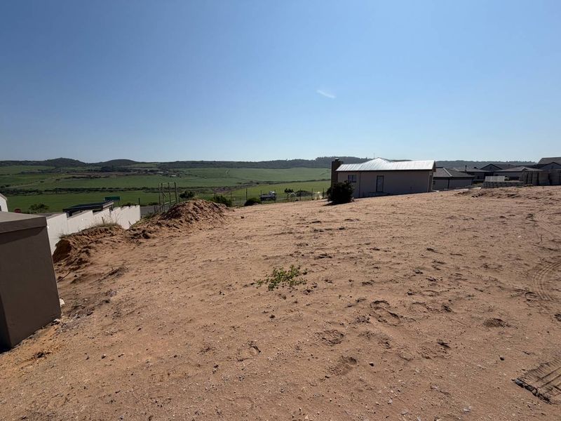 A view of the vacant residential land plot featuring a gentle slope and surrounding landscape views.