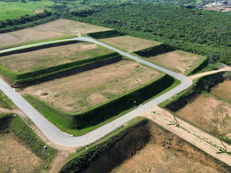 Aerial view of a developed industrial land parcel featuring terraced plots and established paved access roads within a landscaped setting.