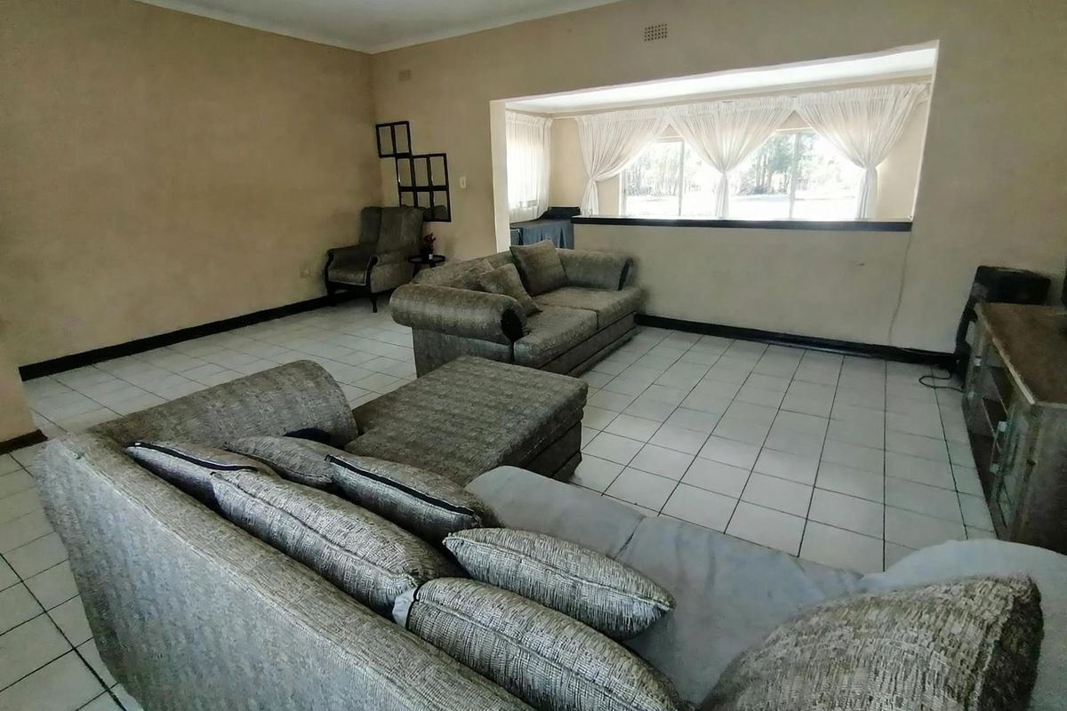 Spacious living room featuring neutral tiled flooring and a large window, offering a blank canvas for modern interior design updates.