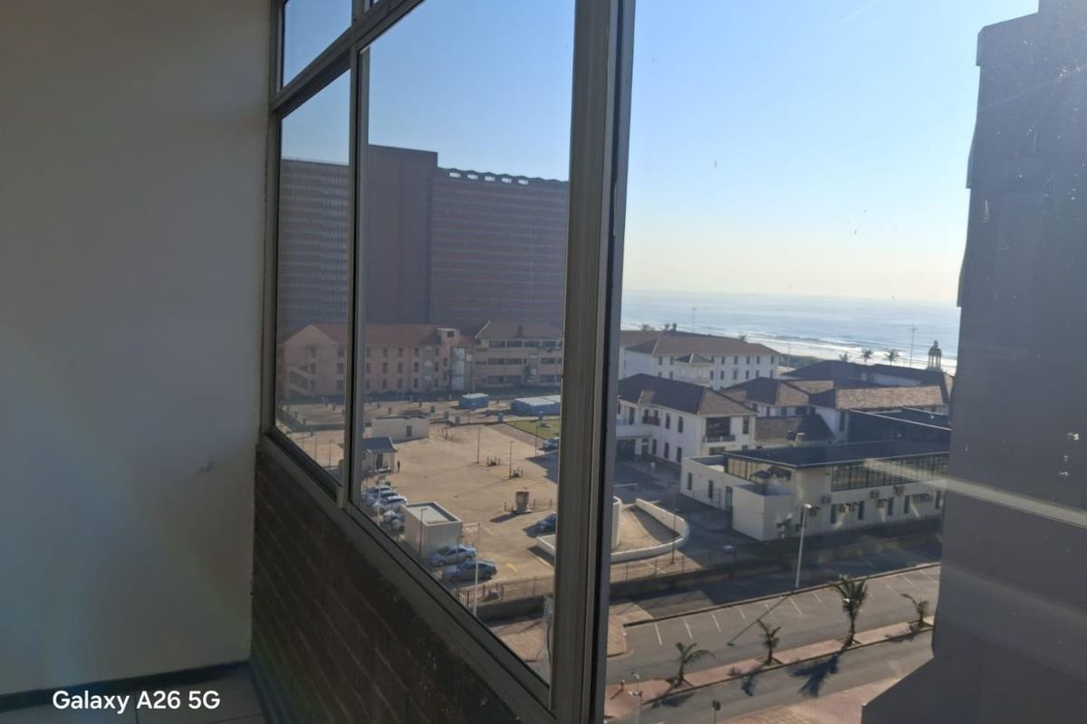 An elevated view from an apartment window overlooking the surrounding neighbourhood and coastline.