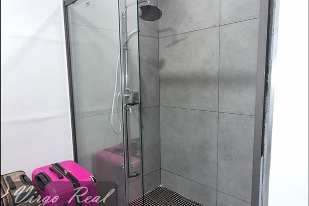 Modern bathroom featuring a walk-in shower with a glass screen, large format grey wall tiles, and contrasting mosaic floor tiling.