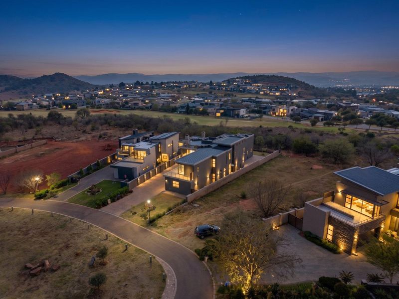 Aerial twilight view of a modern residential estate featuring contemporary multi-story homes with paved driveways and landscaped surroundings.