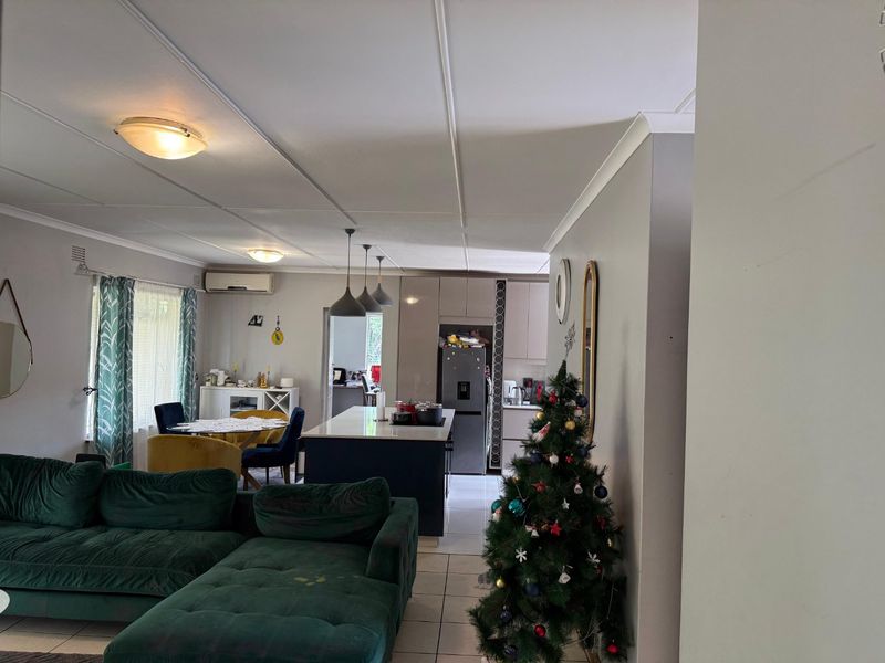 Open-plan living and kitchen area featuring a central island, tiled flooring, and split-system air conditioning, offering a functional and connected layout.