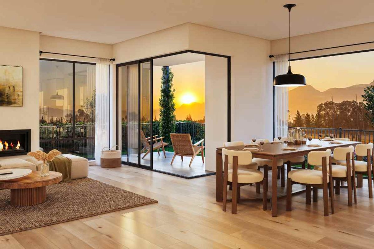 Spacious open-plan living and dining area featuring hardwood floors, a modern built-in fireplace, and large sliding doors opening to a scenic outdoor patio.
